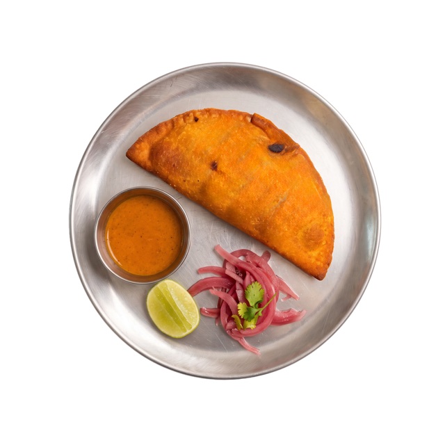 Empanada de Racimal servida con salsa y encurtidos