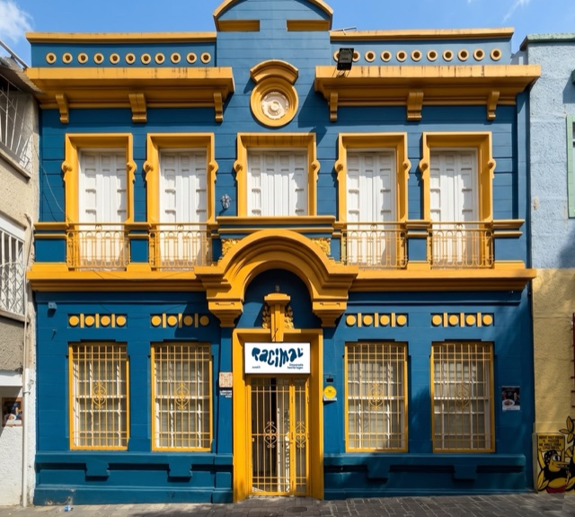 Fachada azul y amarilla de Racimal